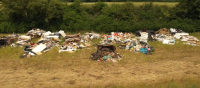 Fly tipping waste dumped in countryside field