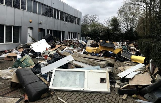 Severe fly tipping with dumped waste outside commercial building