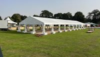 Large outdoor marquee tent setup on grass for events and weddings