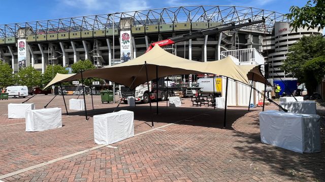 Stretch tent setup with concrete ballasts outside stadium event venue
