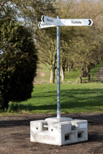 Directional signpost mounted on portable concrete base