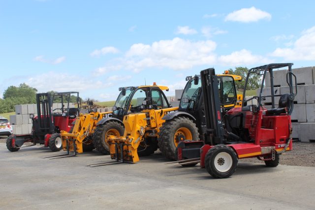Forklifts and telehandlers parked in equipment yard